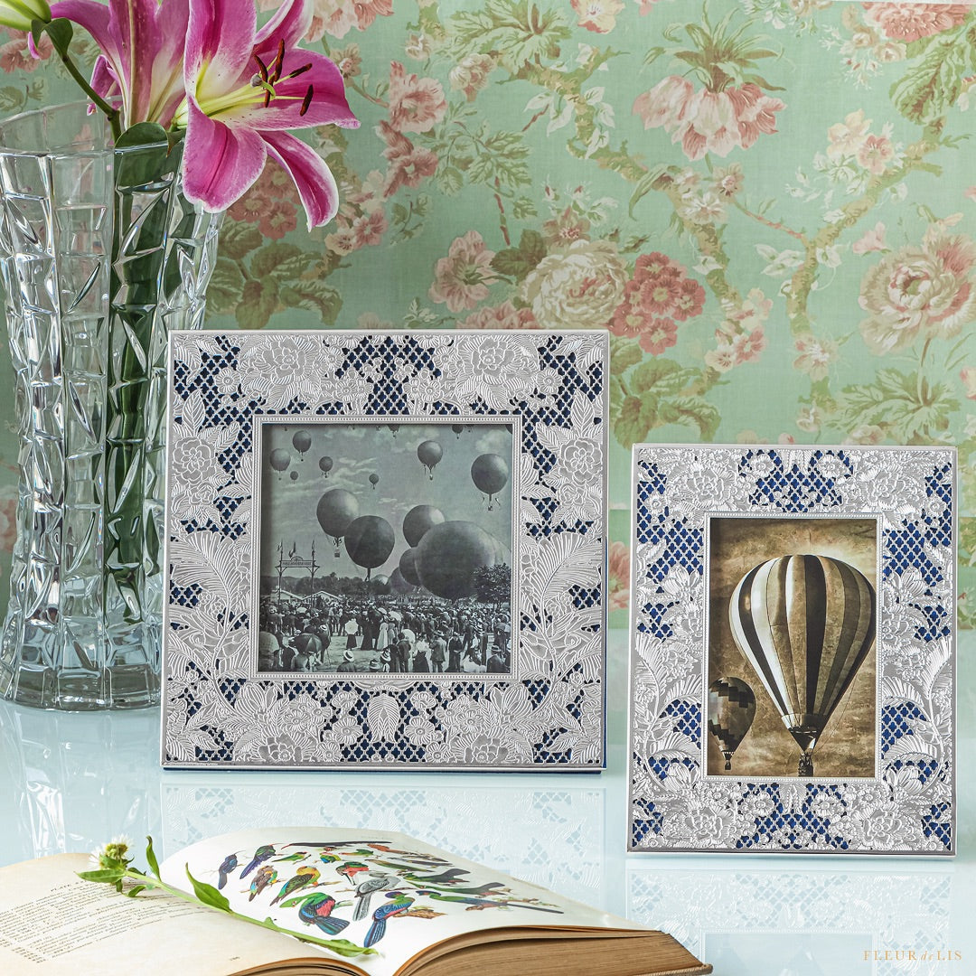 Decorative picture frames with floral and hot air balloon designs on a floral wallpaper background.