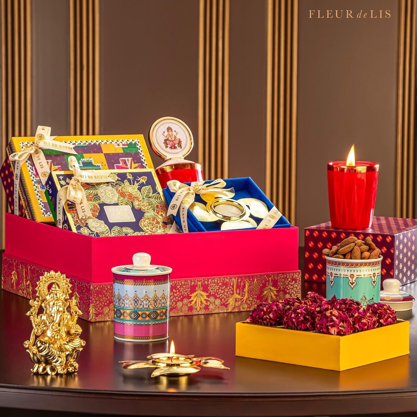 Decorative gift set with candles, flowers, and other items on a table with 'Fleur de Lis' branding.