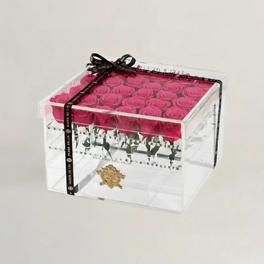 Clear box with pink roses and a black ribbon on a light gray background