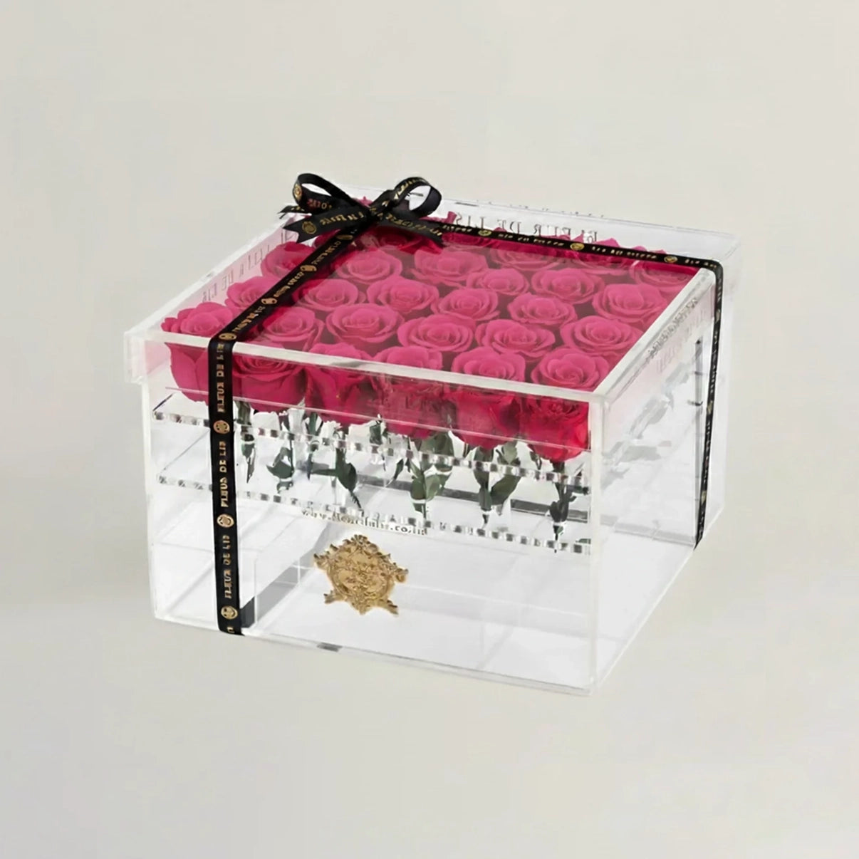 Clear box with pink roses and a black ribbon on a light gray background