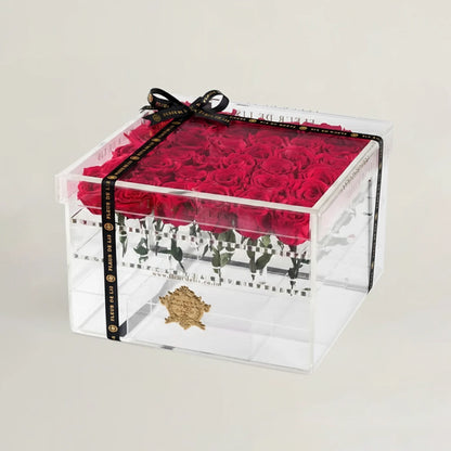 Clear gift box with red roses and a black ribbon on a light gray background