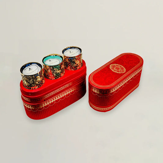 Decorative red box with three small candles on a light gray background