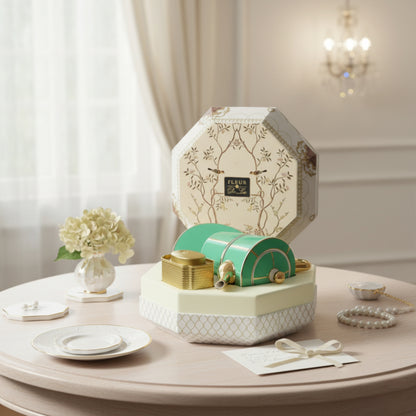 Decorative box with floral design on a table with flowers and plates