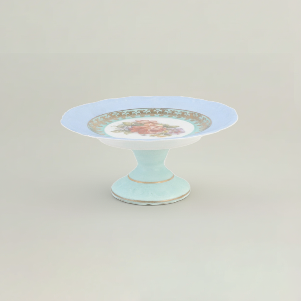 Decorative cake stand with floral design on a light gray background