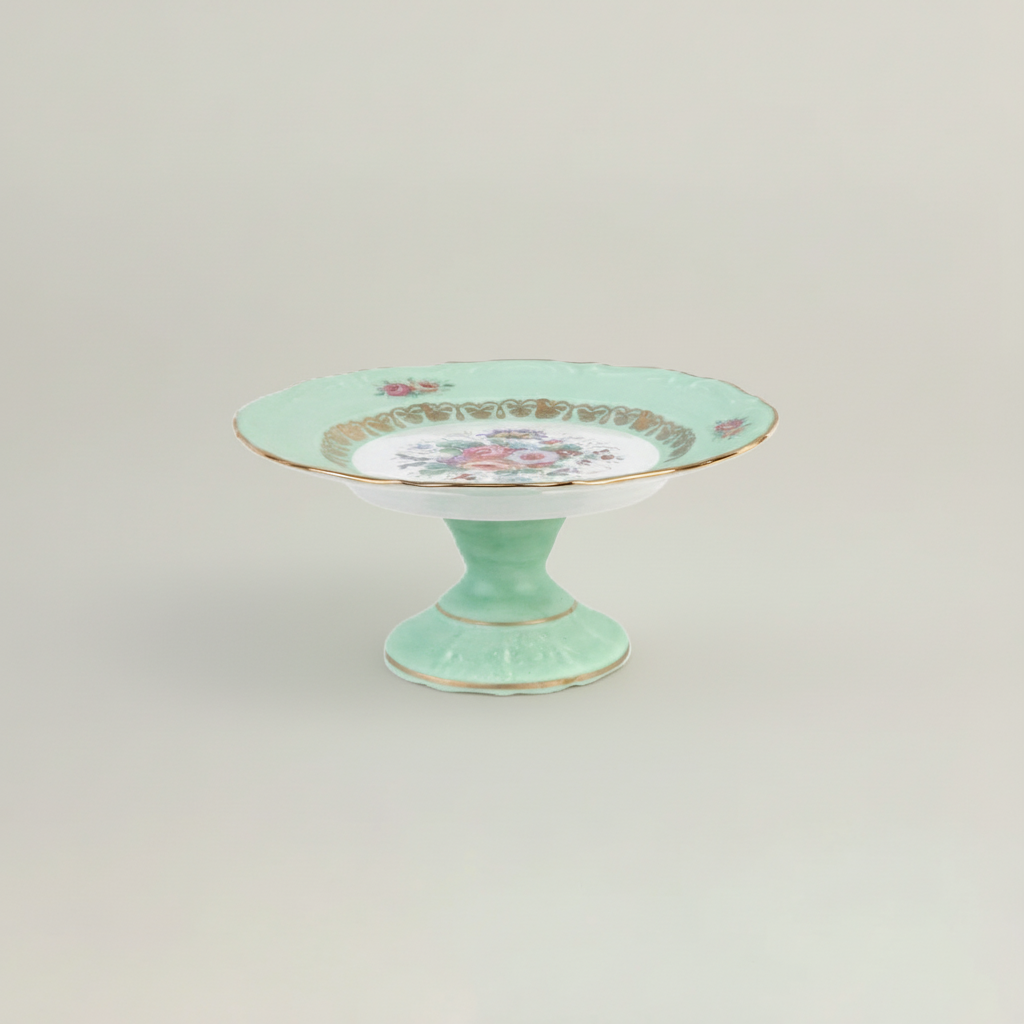 Mint green cake stand with floral design on a light gray background