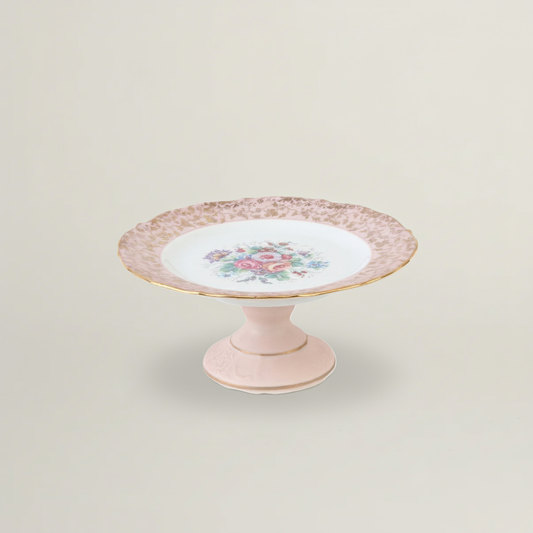 Pink cake stand with floral design on a light beige background