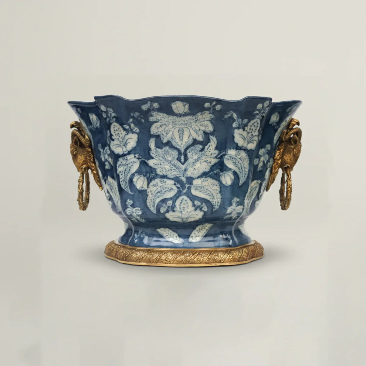 Decorative blue ceramic vase with gold accents on a light gray background