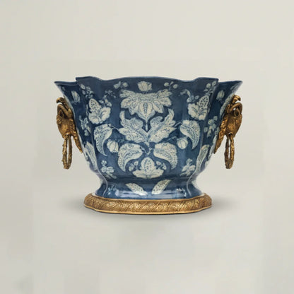 Decorative blue ceramic vase with gold accents on a light gray background