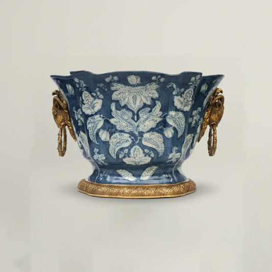 Decorative blue ceramic vase with gold accents on a light gray background