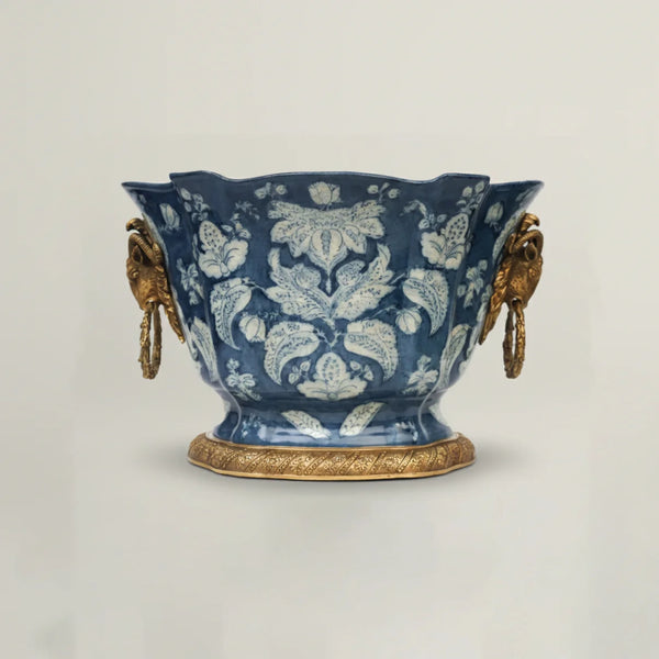 Decorative blue ceramic vase with gold accents on a light gray background