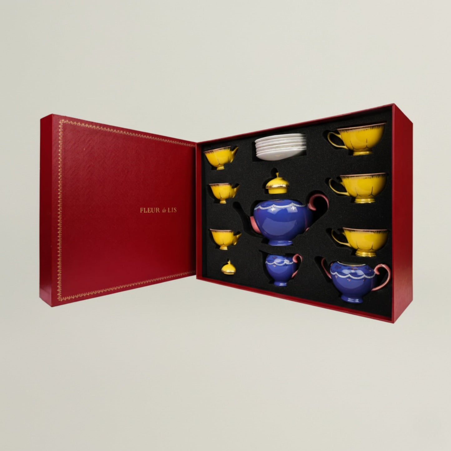 Luxury ceramic tea set featuring yellow cups and a royal blue teapot, presented in a premium Fleur de Lis gift box.
