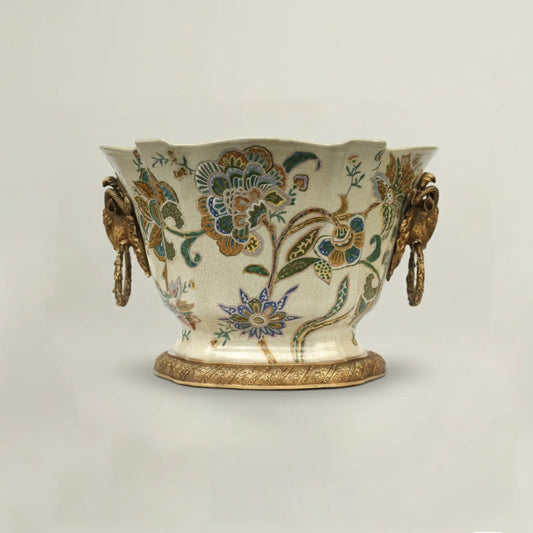 Decorative ceramic vase with floral patterns and gold accents on a light gray background